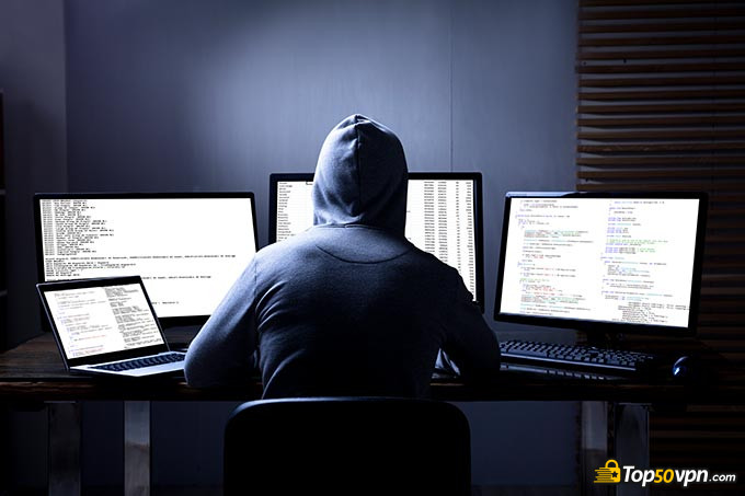 Dedicated IP VPN: a hacker doing some fishy business on his computers.